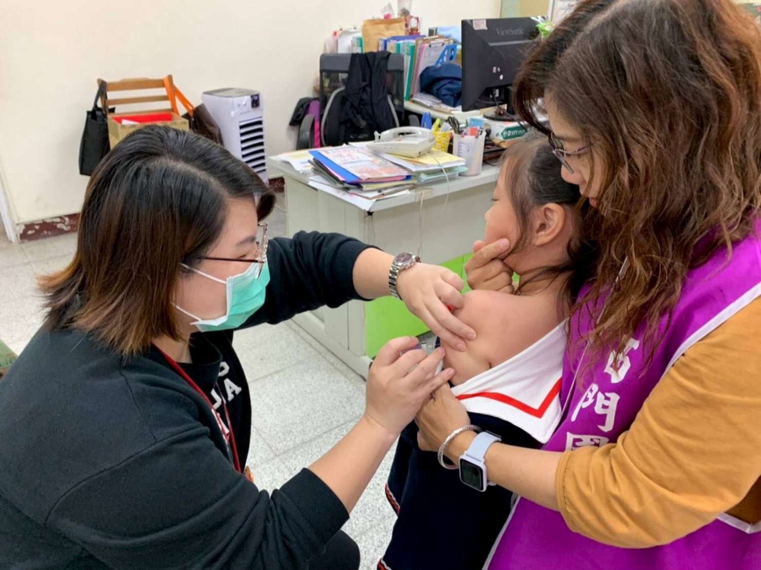志工協助學童接種流感疫苗